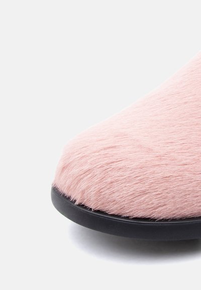 Ροζ παπούτσι από ψεύτικη γούνα με στρογγυλεμένη μύτη, με υφή και μαύρη καουτσούκ σόλα. Απαλή και αφράτη εμφάνιση.