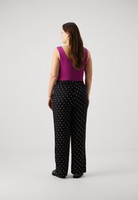 Vero Moda Curve VMCBUMPY WIDE - Trousers - black/white