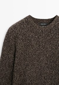 Ciemnobrązowy sweter z wełny o fakturowanym wzorze dzianiny i klasycznym okrągłym dekolcie. Metka na wnętrzu pokazuje "Massimo Dutti" i "100% wełny".