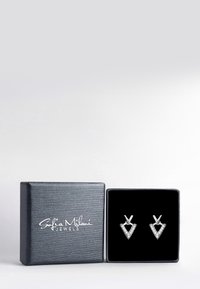 Orecchini in tonalità argento con un design geometrico a triangolo e accenti trasparenti, presentati in una scatola per gioielli nera testurizzata.