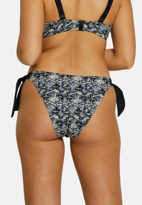 Ensemble de bikini avec un motif serpent en noir, bleu et or. Le bas a des côtés noués et un design taille haute, fabriqué à partir d'un tissu texturé.