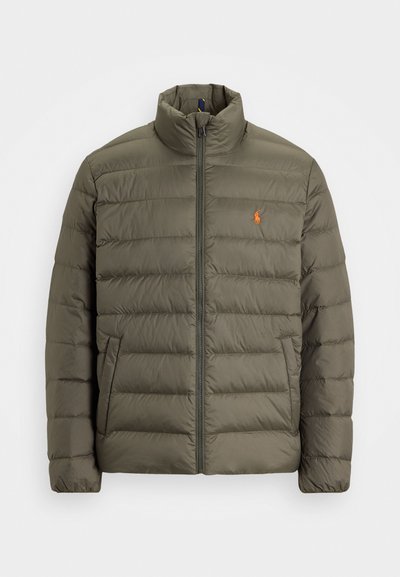 Olivgrön puffjacka, dragkedja fram, hög krage, horisontellt kviltat mönster, ficka på vänster sida, liten orange logotyp på bröstet.