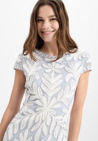 Hellblaues Kleid mit weißer Blumenstickerei, Rundhalsausschnitt und kurzen Ärmeln. Glattes Material mit strukturierten Mustern und zarten Akzenten.