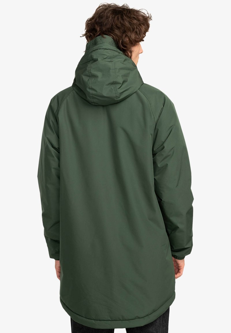 Giacca impermeabile verde con cappuccio, maniche lunghe e texture liscia, con orlo leggermente curvo e senza dettagli hardware visibili.