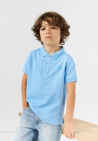 Lichtblauw poloshirt van katoen, met een klassieke kraag en korte mouwen, voorzien van een klein embleem op de borst en een ontspannen pasvorm.