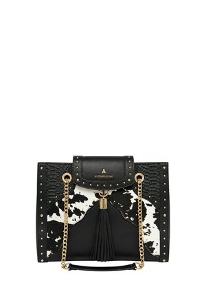Borsa a mano in pelle nera con motivo in pelle di mucca bianco e nero, tracolla in catena dorata, dettaglio con nappina e borchie dorate sui lati e sulla patta.