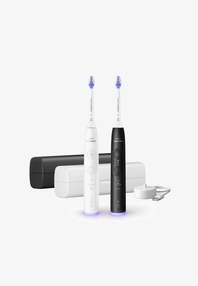 Elektrische tandenborstelset met witte en zwarte handvatten, LED-indicatoren en reinigingsmodi. Inclusief oplader en twee opbergdozen.