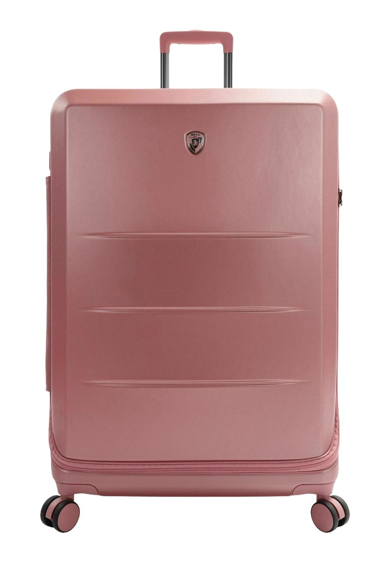 Rosa Hartschalenkoffer mit glatter Oberfläche, horizontalen Rillen, Teleskopgriff und vier schwarzen Rädern. Ausgestattet mit einem metallischen Logo-Emblem.
