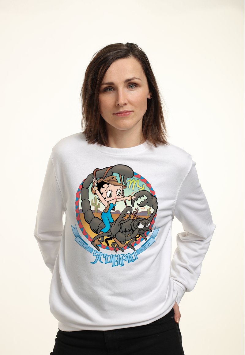 Bílá mikina s barevnou grafickou předlohou znázorňující kreslenou dívku se škorpionem. Design zahrnuje text a stylizované akcenty.