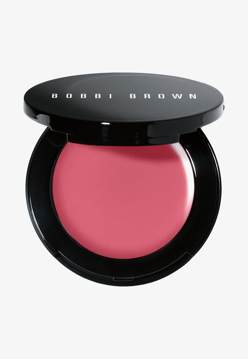 Bobbi Brown Creme Rouge in einem runden schwarzen Kompakt mit glänzender Oberfläche, das ein sanftes rosa Cremeprodukt im Inneren enthält.