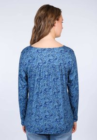 Langärmliges blaues Oberteil mit floralem Muster, mit gefaltetem Rückendetail und weitem Ausschnitt, aus weichem Stoff.