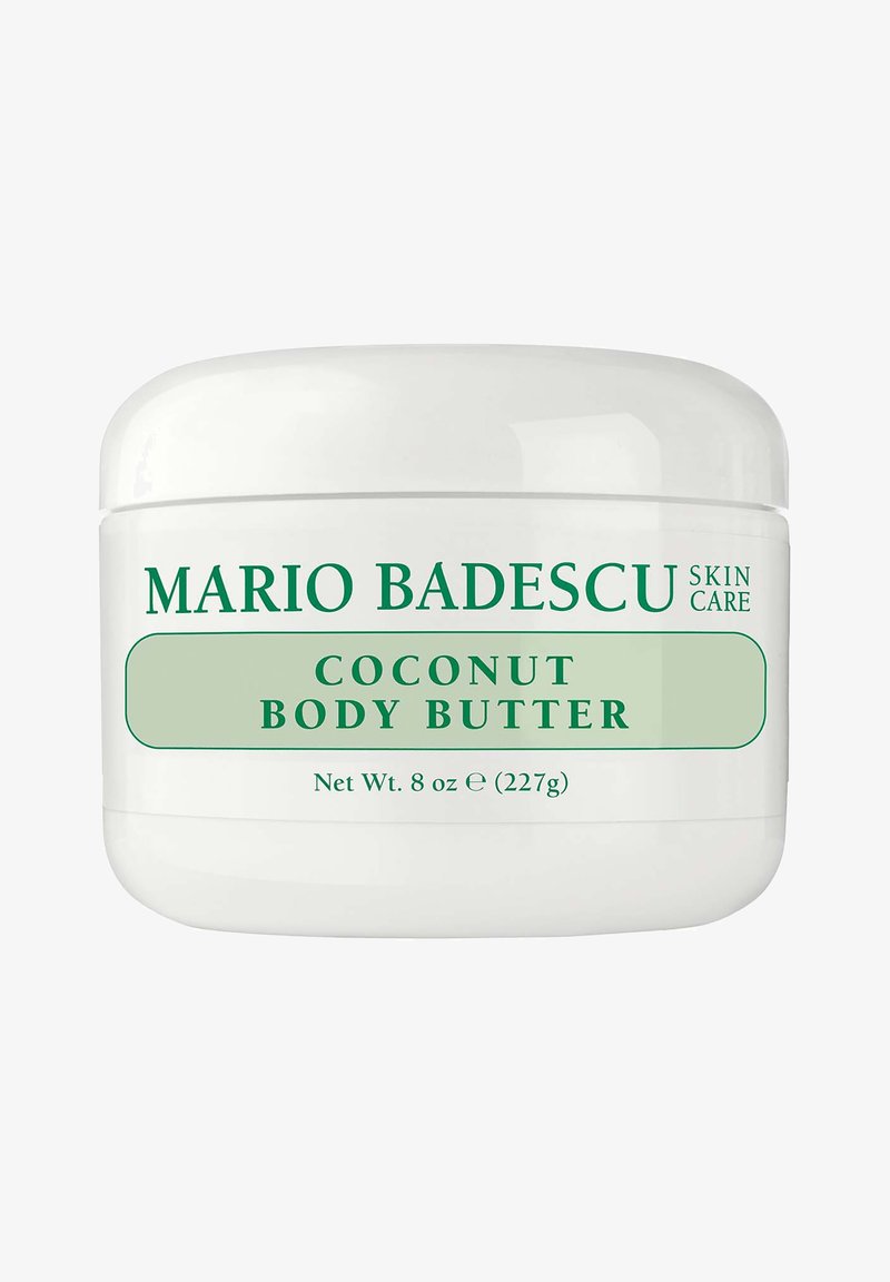 Beurre corporel à la noix de coco Mario Badescu dans un pot blanc de 8 oz (227 g), texte vert sur l'étiquette indiquant la marque et le nom du produit.