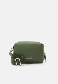 Bolso cruzado de cuero verde con textura granulada, acentos en hardware dorado y correa ajustable con un patrón de logo.