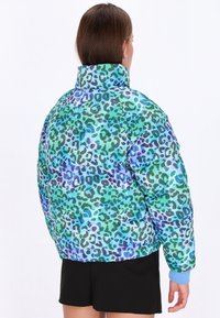 Giacca imbottita con un motivo a stampa leopardata nei colori verde, blu e viola. Presenta un colletto alto, polsini elasticizzati e una vestibilità comoda.
