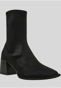 Stivale alla caviglia nero realizzato in suede liscio, con punta appuntita, superficie testurizzata e tacco a blocco chunky.