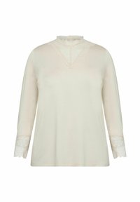 Kremasta bluza s dugim rukavima i visokim izrezom, koja ima čipkastu obrubu na ovratniku i valovite čipkaste detalje na rukavima.