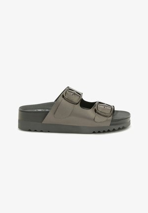 Sort slidesandal med to justerbare metalgrå remme og spænder på en tyk sål med tekstureret mønster.