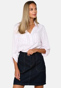 White button-up shirt with pink stripes, paired with a high-waisted dark denim skirt featuring front pockets and visible stitching details.