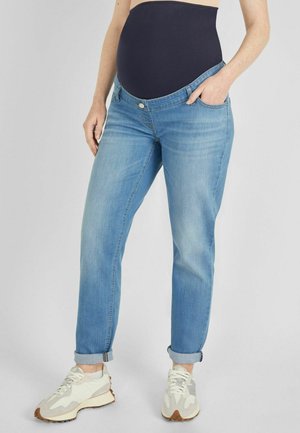 Maternity jeans in light blue denim with a dark navy elastic waistband. The fit is relaxed, featuring a rolled cuff and side pockets.
