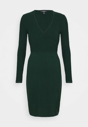 Robe en maille vert foncé avec manches longues, corsage en maille côtelée style portefeuille, taille ajustée et jupe droite.