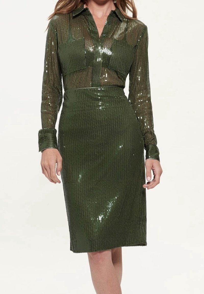 Zielona sukienka z cekinami o dopasowanej sylwetce, długich rękawach i kołnierzu. Teksturowany materiał odbija światło. Projekt o długości do kolan z gładkim wykończeniem.