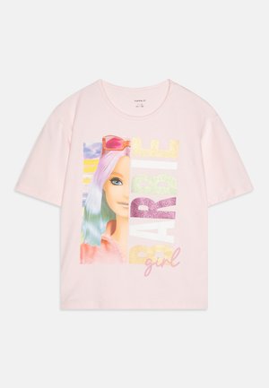 T-shirt rosa de manga curta com uma gráfica colorida de uma boneca com cabelo roxo e azul, óculos de sol e o texto "BARBIE girl" em glitter.