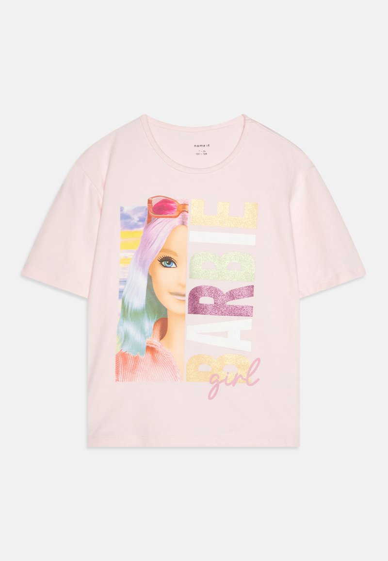 T-shirt rose à manches courtes avec un graphique coloré d'une poupée aux cheveux violets et bleus, lunettes de soleil, et le texte "BARBIE girl" en paillettes.