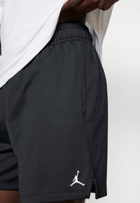 Μαύροι αθλητικοί σορτς από δίχτυ με ελαστική μέση, πλαϊνές τσέπες και λευκό λογότυπο Jumpman στο κάτω αριστερό τελείωμα. Λείο υλικό, διαπνέον ύφασμα.