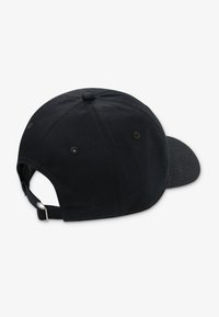 Gorra de béisbol de algodón negro con visera curva, correa ajustable y tejido texturizado. Presenta detalles de costuras y orificios de ventilación.
