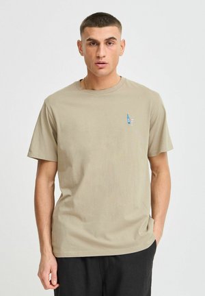 Beige cotton t-shirt with short sleeves, featuring a small embroidered design of a bottle and glass on the left chest. Crew neckline.