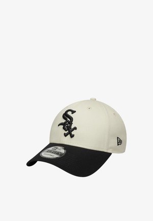 Gorra de béisbol color beige con visera negra, que presenta un logotipo 'Sox' bordado en negro en la parte frontal. Hecha de algodón con un diseño estructurado.