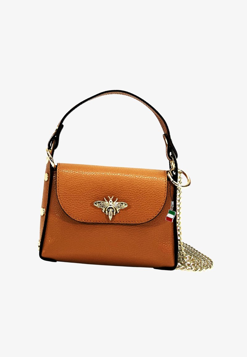 Sac en cuir tan avec un emblème doré de abeille, anse supérieure et bandoulière amovible en chaîne. Doté d'une fermeture à pression et de clous décoratifs dorés.