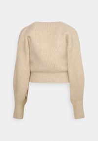 Beige ribbat stickad tröja med en kortad design, långa ärmar och rundad halsringning. Mjuk textur med synliga sömnadsdetaljer.