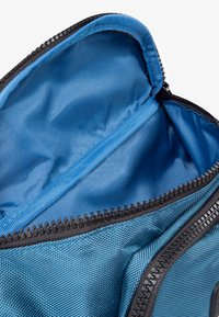 Blue fabric bag interior with a smooth texture. Features a black zipper and a separate zippered compartment.