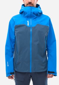 Blau und grau wasserdichte Jacke mit Kapuze, mit einem Reißverschluss vorne, zwei Seitentaschen und einem strukturierten Stoff. Logo auf der Brust angezeigt.