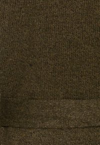 Strickstoff in dunkelolivgrün mit einem strukturierten Muster und einem glatten, kontrastierenden Bund am unteren Ende.