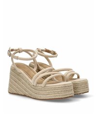 Sandalias de cuña beige con múltiples tiras entrelazadas, hechas de tela y con una suela de cuerda de yute tejida con un acabado texturizado.