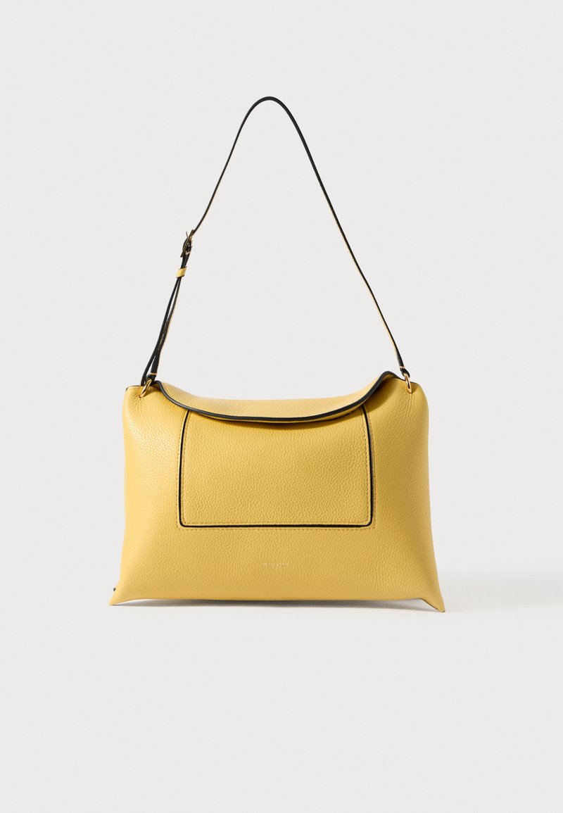 Dzeltens ādas plecu soma ar priekšējo kabatu un regulējamu melnu siksnu, attēlots uz balta fona.