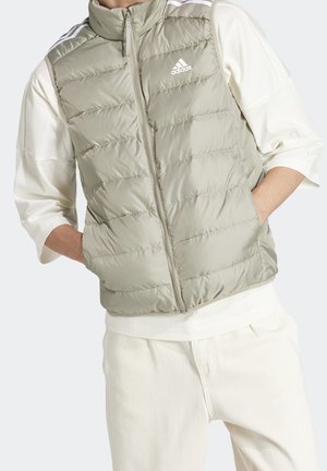 Padded vest in light olive green, made of shiny material with zip closure and high collar. Features white Adidas logo and contrasting stripes.