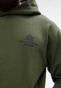 Olivovo zelená mikina s kapucňou vyrobená z jemného materiálu, s tmavošedou potlačou planéty a textom "Mare O'Polo DENIM".