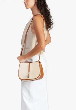 Bolso beis con correa de cuero marrón claro, que presenta un cierre y detalle de candado en tono dorado. Forma estructurada con textura suave y colores contrastantes.