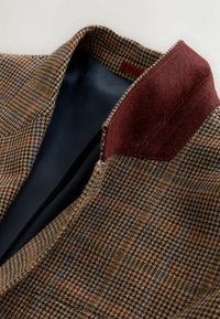 Brown and navy patterned blazer with a textured burgundy collar, showcasing a classic design and smooth black lining.