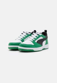 Scarpe sportive verde e bianche realizzate in materiale sintetico. Presentano una tomaia perforata, dettagli neri e lacci bianchi.