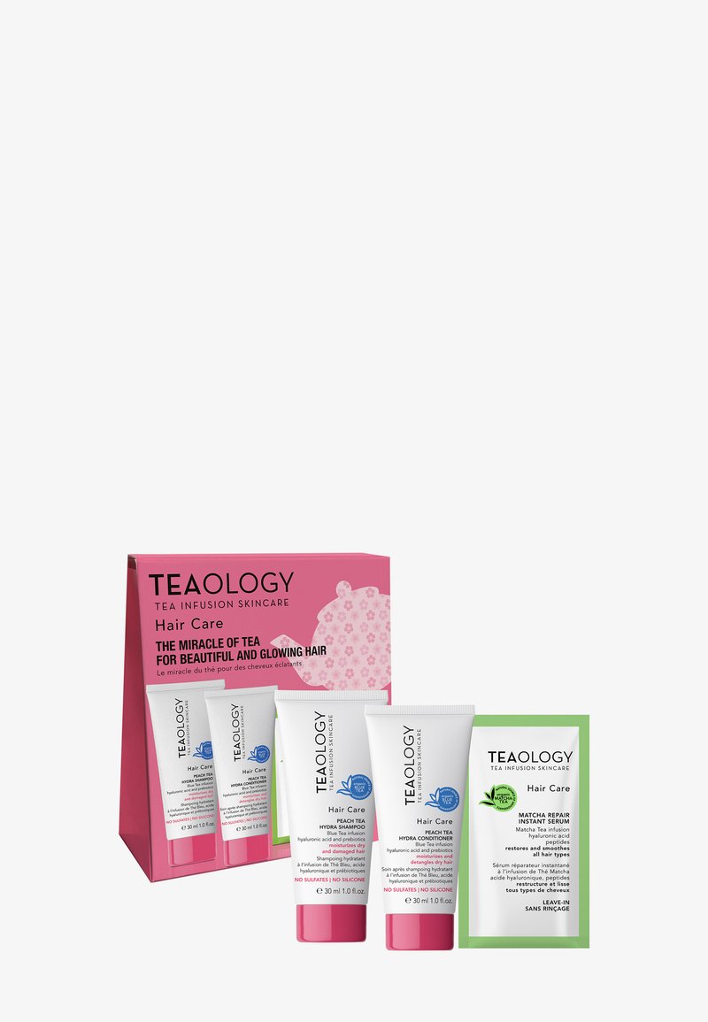 Kit per la cura dei capelli Teaology che include tre tubi: shampoo al tè alla pesca, balsamo al tè alla pesca e siero riparatore al matcha verde, con packaging rosa e verde.
