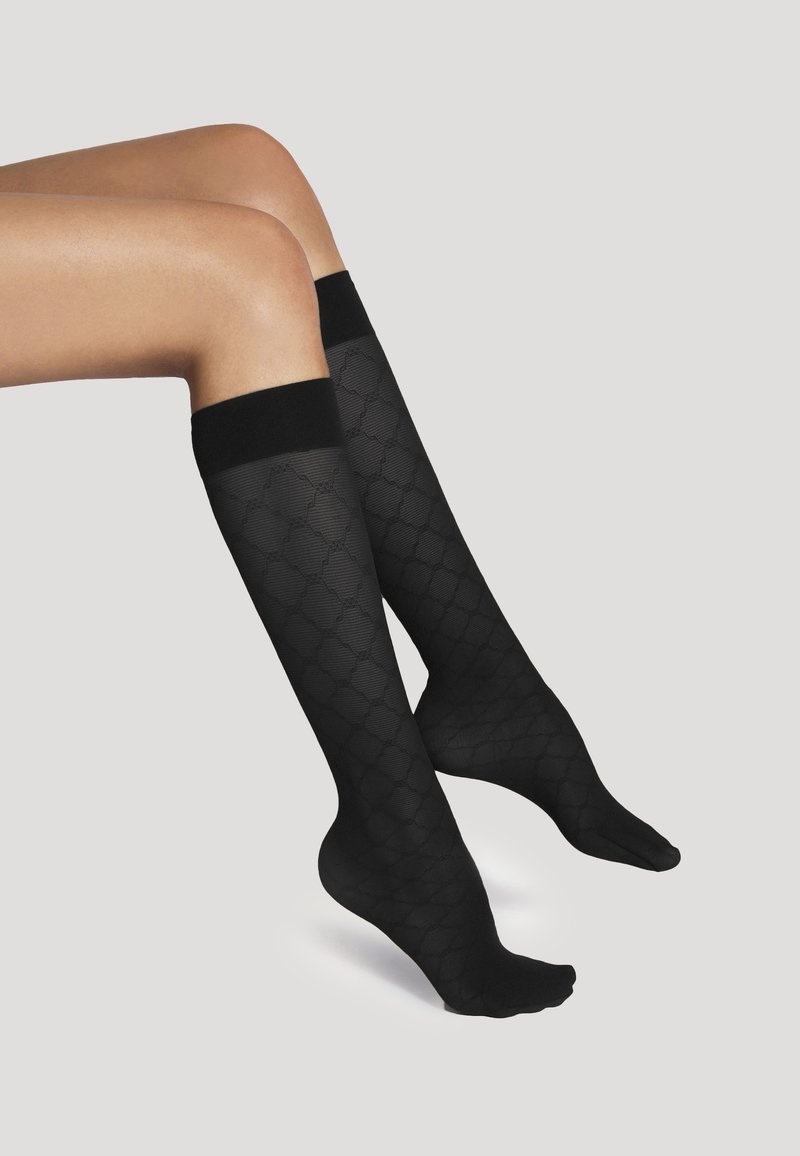 Calze nere fino al ginocchio con un motivo a texture che presenta forme a diamante. La banda superiore è di un nero uniforme. Finitura del tessuto liscia.