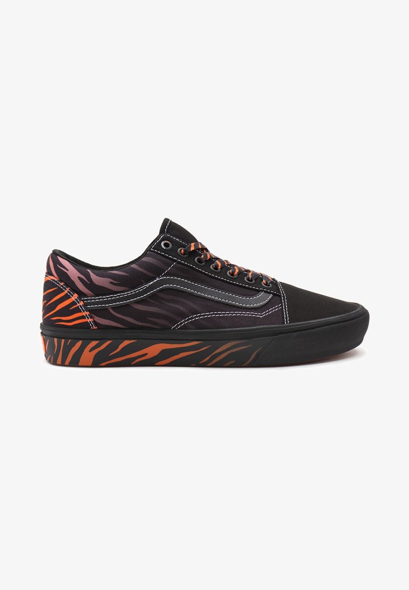 Basket basse noire avec des rayures tigre orange et noires sur la semelle, le talon et les lacets, coutures blanches et bande latérale grise.