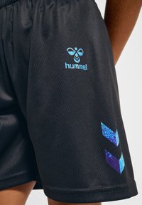 Svarta sportiga shorts i slätt tyg, med en blå "hummel"-logotyp och två blå chevron-accenter på sidan.