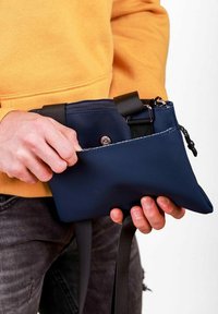 Námořnicky modrá obdélníková taška z tkaniny, vybavená zipem, nastavitelným popruhem a přední kapsou s patentním zapínáním. Lehký design.