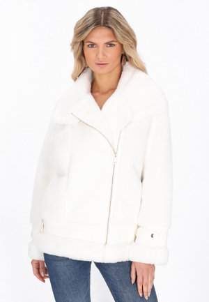 Witte faux bont jas met een brede kraag, ritssluiting en knoopaccenten. Heeft een zachte textuur en een iets oversized pasvorm, gecombineerd met jeans.