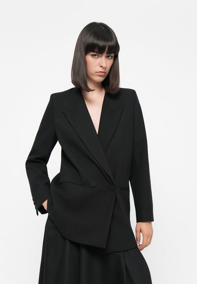 Zwarte op maat gemaakte blazer met een dubbele rij knopen, scherpe revers en een gestructureerde afwerking, voorzien van twee knopen en zijzakken.